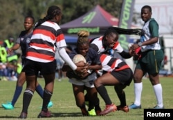 Shingi Chigegede, a member of the Zimbiru Rugby Academy Club, an all-female rugby team, makes a try during a legue match against Old Georgians sports club in the capital Harare, in Zimbabwe, April 29, 2023. (REUTERS/Philimon Bulawayo)