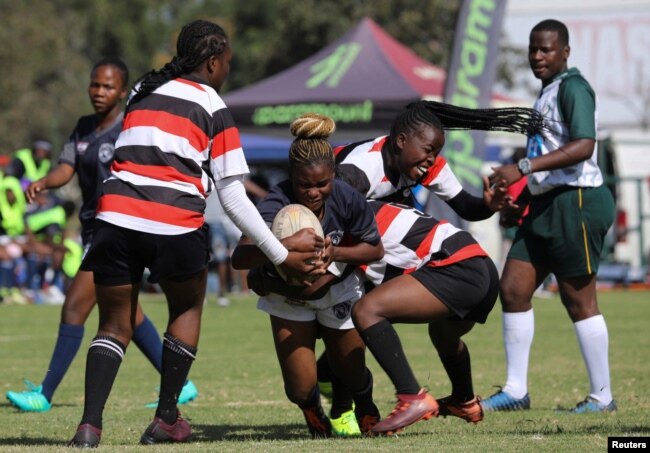 Shingi Chigegede, a member of the Zimbiru Rugby Academy Club, an all-female rugby team, makes a try during a legue match against Old Georgians sports club in the capital Harare, in Zimbabwe, April 29, 2023. (REUTERS/Philimon Bulawayo)