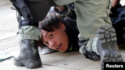 A protester is detained by riot police officers during an anti-government demonstration in Hong Kong, China, Nov. 10, 2019. 