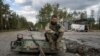 Seorang tentara Ukraina tengah merokok setelah berhasil menemukan dan mengidentifikasi jenazah rekannya yang tewas di Kota Lyman, Ukraina, pada 3 Oktober 2022. (Foto: AP/Evgeniy Maloletka)