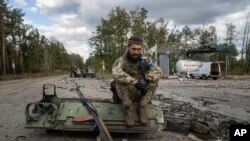 Seorang tentara Ukraina tengah merokok setelah berhasil menemukan dan mengidentifikasi jenazah rekannya yang tewas di Kota Lyman, Ukraina, pada 3 Oktober 2022. (Foto: AP/Evgeniy Maloletka)