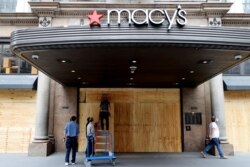 Workers board up the Macy's store in Herald Square after it was damaged and looted by protesters who rallied against the death in Minneapolis police custody of George Floyd, in the Manhattan borough of New York City, June 2, 2020.