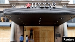 Workers board up the Macy's store in Herald Square after it was damaged and looted by protesters who rallied against the death in Minneapolis police custody of George Floyd, in the Manhattan borough of New York City, June 2, 2020. 