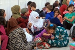 FILE - Syrian displaced families, who fled violence after the Turkish offensive in Syria, are seen at a refugee camp in Bardarash on the outskirts of Dohuk, Iraq, Oct. 25, 2019.