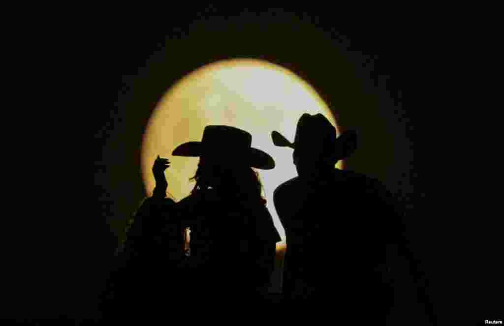 Espectadores observan la luna llena durante el eclipse lunar en las Dunas de Samalayuca, en las afueras de Ciudad Juárez, México, el 17 de septiembre de 2024.&nbsp;