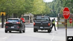 FILE - Security guards open a gate for motorists at the visitor entrance to Fort Lee, Virginia.