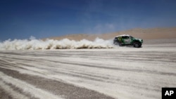 FILE - Driver Stephane Peterhansel and co-driver Jean Paul Cottret, both from France, compete in the 13th stage of the 2012 Argentina-Chile-Peru Dakar Rally between Nazca and Pisco, Peru, Jan. 14, 2012.