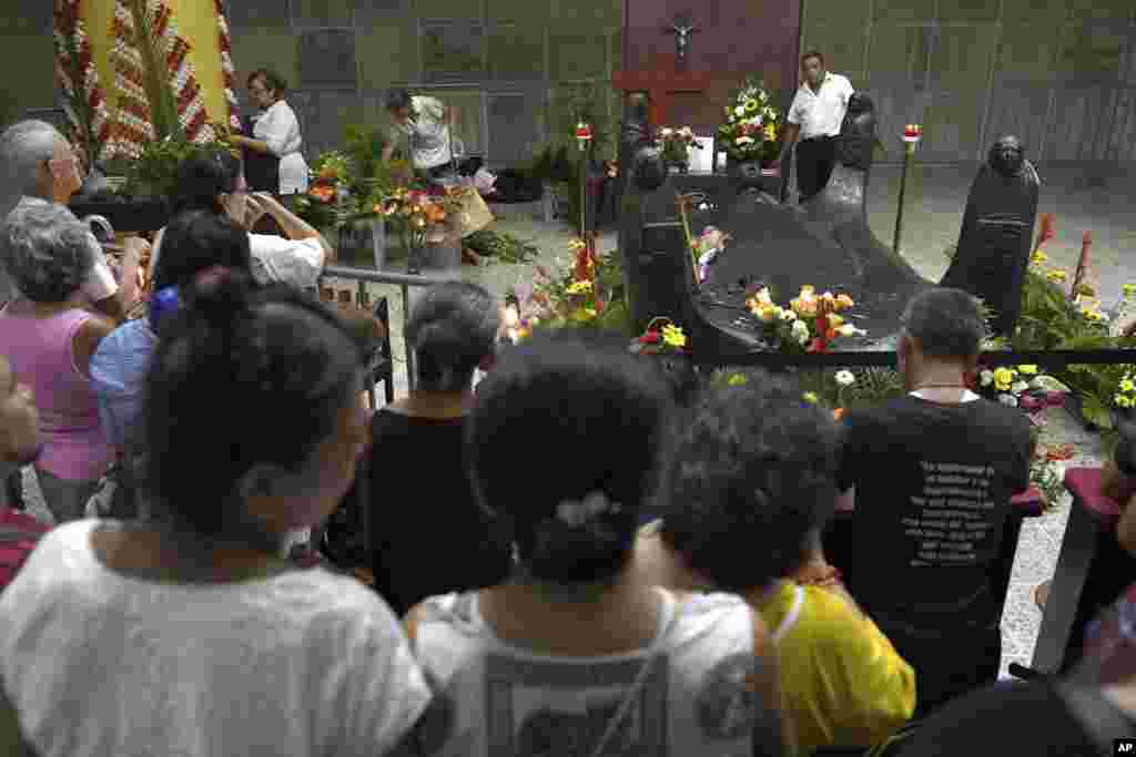 La gente reza frente a la tumba del arzobispo Óscar Arnulfo Romero, en la Catedral Metropolitana de San Salvador, El Salvador, el sábado 13 de octubre de 2018. El Papa Francisco canonizó el domingo a Romero, al papa Paulo VI y a otros cinco betatos, en Roma. (Foto AP / Salvador Meléndez)