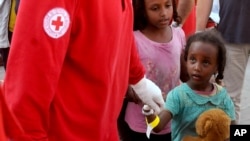 A child holding a teddy bear disembarks from the Norwegian cargo ship Siem Pilot after being rescued in the Mediterranean Sea, at Palermo harbor, Italy, July 25, 2015. 