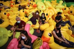 Pro-democracy activists sit on inflatable ducks as they protest after the constitutional court's ruling on Prime Minister Prayuth Chan-Ocha's conflict of interest case, in Bangkok, Thailand, Dec. 2, 2020.