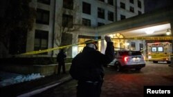 A police officer walks under the police line after a fatal mass shooting at a condominium building in the Toronto suburb of Vaughan, Ontario, Canada Dec. 19, 2022. 