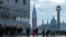 People walk through across a makeshift walkway over the flooded St. Mark's Square in Venice, Italy.