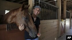 Timea Hunter poses for a photograph at the Family Horse Academy, where she is hoping to organize education for a group of children during the coronavirus pandemic, Friday, July 31, 2020, in Southwest Ranches, Fla. (AP Photo/Lynne Sladky)