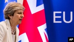 FILE - British Prime Minister Theresa May prepares to address a press conference at an EU summit in Brussels, June 23, 2017.