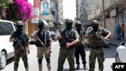 Militan Palestina Brigade al-Nasser Salah al-Deen Brigades, sayap dari Komite Perlawanan Populer (PRC), memberikan konferensi pers di kota Gaza (5/7). (AFP/Mohammed Abed)