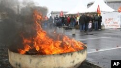 Striking employees block the main entrance of the Donges refinery, western France, Saturday Oct. 23, 2010. Travelers in France are facing another day of spotty train service and gas shortages as strikes against the government's pension reform enter their