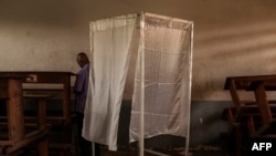 Un électeur vérifie son bulletin de vote dans un bureau de vote lors des élections présidentielles à Brazzaville le 20 mars 2016.