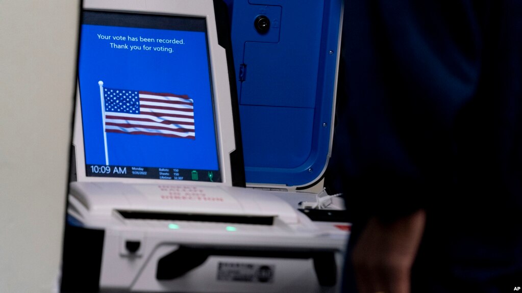 资料照片：在弗吉尼亚州亚历山德里亚的一处提前投票地点，一名选民将其选票输入投票机。(2022年9月26日) (photo:VOA)