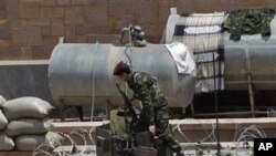 A Yemeni soldier stands on top of an armored personnel carrier, guarding the Yemeni Central Bank in Sana'a, March 26, 2011