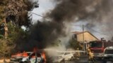 Firefighters douse a car blaze in the southern Israeli city of Ashkelon after a rocket attack from Gaza on October 9, 2023.