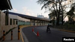 Archivo - Un policía vigila en bicicleta después que el presidente Nayib Bukele ordenó el cierre del Aeropuerto Internacional Oscar Romero en San Luis Talpa, El Salvador, el 16 de marzo de 2020.