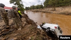 Spasilački tim gleda da li ima nekog u kombiju koji je uleteo u Severnoj Karolini (Foto:Travis Long/ The News & Observer/via REUTERS)