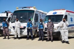 Civil defense members stand outside the new Salt government hospital in the city of Salt, Jordan, March 13, 2021.