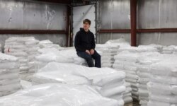FILE - CEO and founder of Eat Just Josh Tetrick sits on bags of plant protein at the Eat Just facility in Appleton, Minnesota, December 2019. (Eat Just, Inc./Handout via REUTERS)