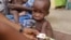 FILE - A doctor attends to a malnourished child at a refugee camp in Yola, Nigeria. The number of people worldwide in need of humanitarian assistance has soared to a record-breaking 130 million, U.N. figures show.