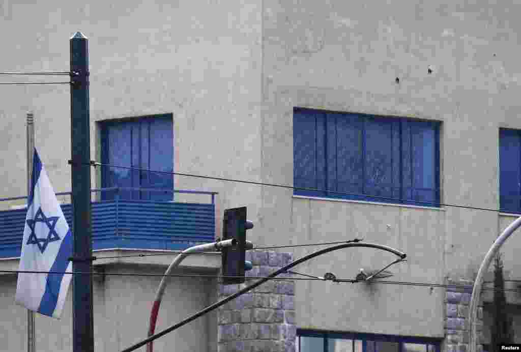 Bullets holes can be seen of the wall of the Israeli embassy in Athens, Dec. 12, 2014.