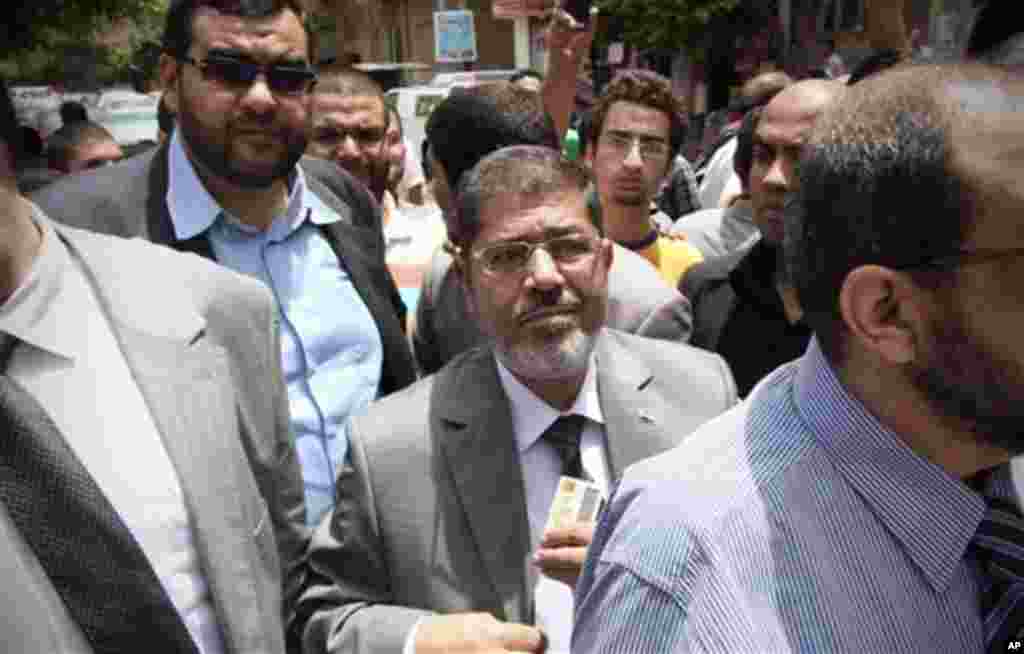 Egyptian Muslim Brotherhood presidential candidate Mohammed Morsi, waits in line to cast his vote outside a polling center, in Zakazik 80 Kilometers (50 miles) north of Cairo, Egypt, Wednesday, May 23, 2012. On Wednesday morning, Egypt commenced two days 