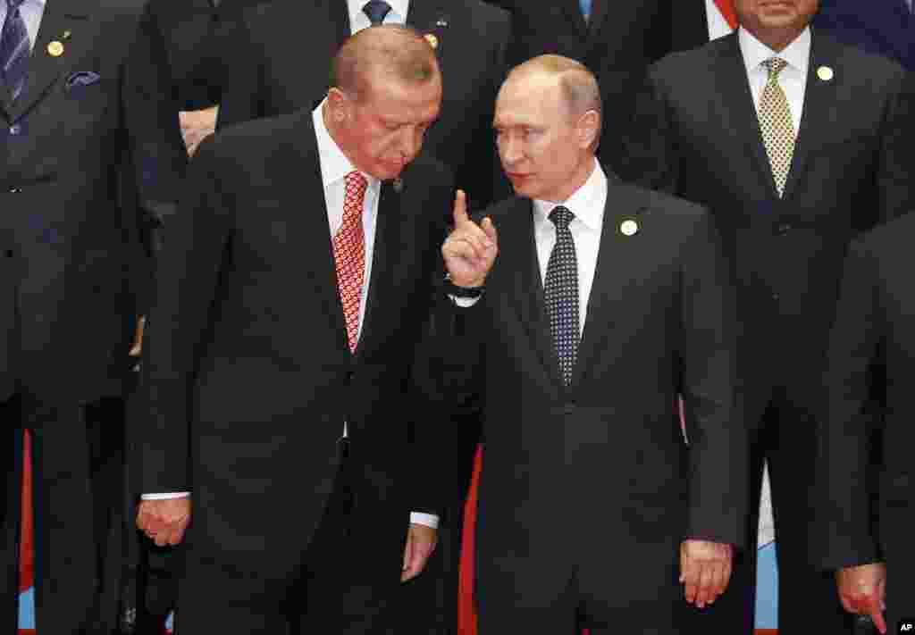 Presiden Turki Recep Tayyip Erdogan dan Presiden Rusia Vladimir Putin berbincang dalam sesi foto pada KTT G20 di Hangzhou, provinsi Zhejiang, China (4/9). (AP/Ng Han Guan)