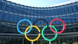 FILE -: The Olympic rings in front of the International Olympic Committee in Lausanne, Switzerland, March 24, 2020.
