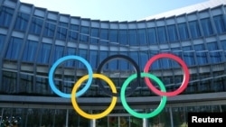FILE -: The Olympic rings are pictured in front of the International Olympic Committee (IOC) during the coronavirus disease (COVID-19) outbreak in Lausanne, Switzerland, March 24, 2020.