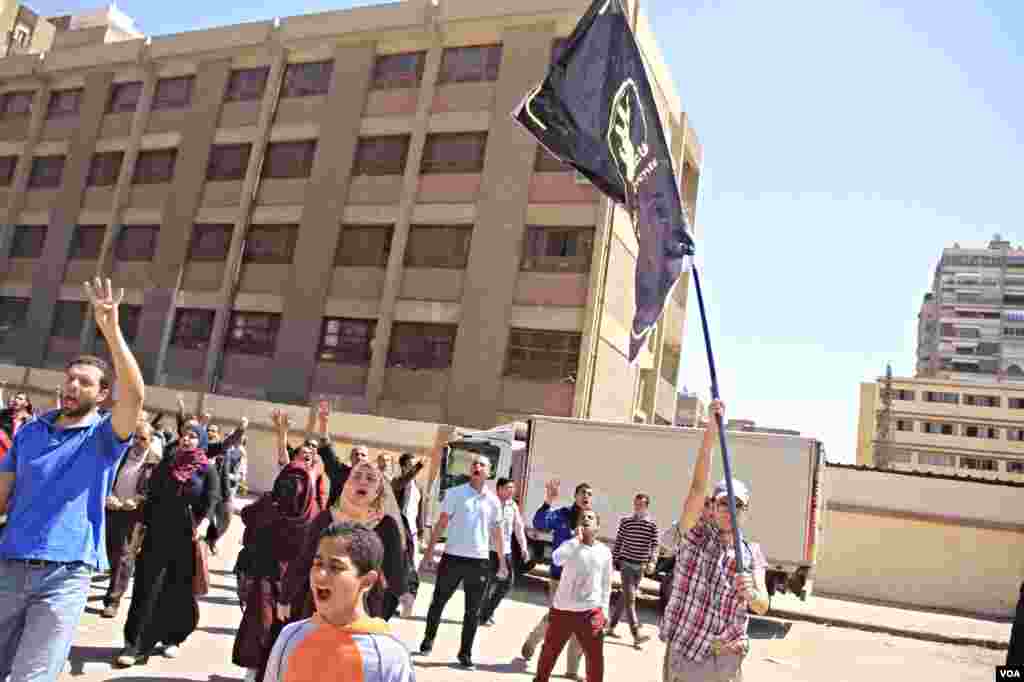 Protesters march through Cairo holding up four-fingers, a hand sign in memory of last year's deadly crackdown on supporters of ousted President Mohamed Morsi, March 28, 2014. (Hamada Elrassam/VOA)