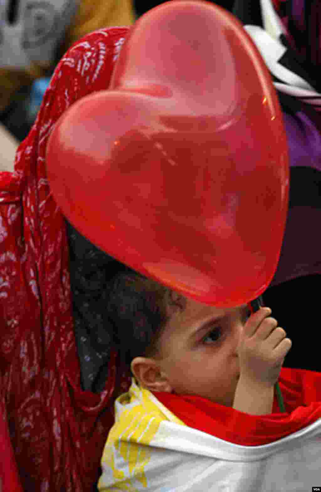 A Muslim boy holds a balloon after Eid al-Fitr prayers marking the end of Ramadan in Tahrir Square in Cairo, Egypt, Aug. 30, 2011. AP
