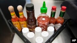 In this file photo, salt shakers and other condiments at a restaurant in Alexandria, Va., May 14, 2013.