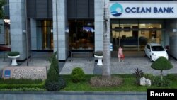  A woman walks out of a branch of Ocean Bank located in the PetroVietnam building in Hanoi, Vietnam, Sept. 1, 2017. 