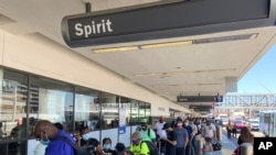 Passengers line up outside the Spirit Airlines terminal at Los Angeles International Airport in Los Angeles on Tuesday, Aug. 3, 2021. Spirit Airlines canceled more than half its schedule Tuesday, and American Airlines struggled to recover from…