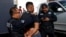 A migrant, who is part of a caravan traveling en route to the United States, is detained by police officers for being drunk outside a shelter in Tijuana, Mexico, Nov. 17, 2018.