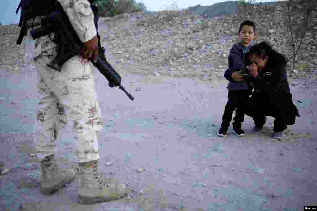  Guatemalan migrant Ledy Perez and her son Anthony ask a member of the Mexican National Guard to let them cross into the United States, as seen from Ciudad Juarez, Mexico, July 22, 2019. 