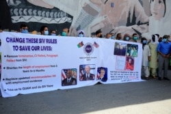 FILE - Former Afghan interpreters hold placards during a demonstrations against the U.S. government, in front of the U.S. Embassy in Kabul, June 25, 2021. The House voted July 22 to allow in Afghans who worked alongside Americans in the war.