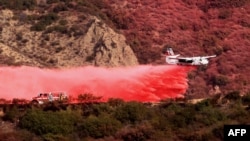 An aircraft drops retardant on a mountainside as the Franklin Fire burns in Malibu, California, on Dec. 11, 2024.