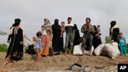 Members of Myanmar's Muslim Rohingya minority wait for a boat to cross a canal at Shah Porir Deep, in Teknak, Bangladesh, Aug. 31, 2017. Last week, a group of ethnic minority Rohingya insurgents attacked at least two dozen police posts in Myanmar's Rakhine state, triggering fighting with security forces that left more than 100 people dead and forced at least 18,000 Rohingya to flee into neighboring Bangladesh.