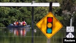 A rescue team navigates its boat through flooded streets as the Tar River crests in the aftermath of Hurricane Matthew, in Princeville, North Carolina, Oct. 13, 2016.