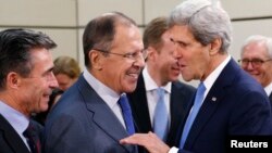 U.S. Secretary of State John Kerry (R) talks to Russia's Foreign Minister Sergei Lavrov, next to NATO Secretary General Anders Fogh Rasmussen (L) during a NATO-Russia foreign ministers meeting at the Alliance headquarters in Brussels, Dec. 4, 2013. 