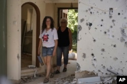 Hadas Eilon-Carmi, left, and her mother, Liora Eilon, walk through Liora's home, which was destroyed during the Oct. 7, 2023, Hamas attack, in Kibbutz Kfar Aza, Israel, on Aug. 18, 2024.