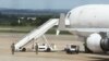 Zimbabwean armed soldiers patrol around a United States registered cargo plane at Harare International Airport in Harare, Zimbabwe, Monday, Feb,15.2016. Zimbabwean aviation authorities impounded a U.S.-registered cargo jet after a dead body later believed to be a stowaway and millions of South African rand were found on board, a senior official said Monday. (AP Photo/Tsvangirayi Mukwazhi)