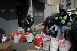 Civil protection volunteers prepare bags with food donated by residents in Rome's working-class Tufello neighborhood, April 2, 2020. Rome residents have donated food to help people who have lost even their low-income jobs due to the pandemic.