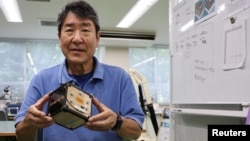 Takao Doi, a former Japanese astronaut and professor at Kyoto University, holds an engineering model of LignoSat during an interview with Reuters at his laboratory at Kyoto University in Kyoto, Japan, October 25, 2024. (REUTERS/Irene Wang)